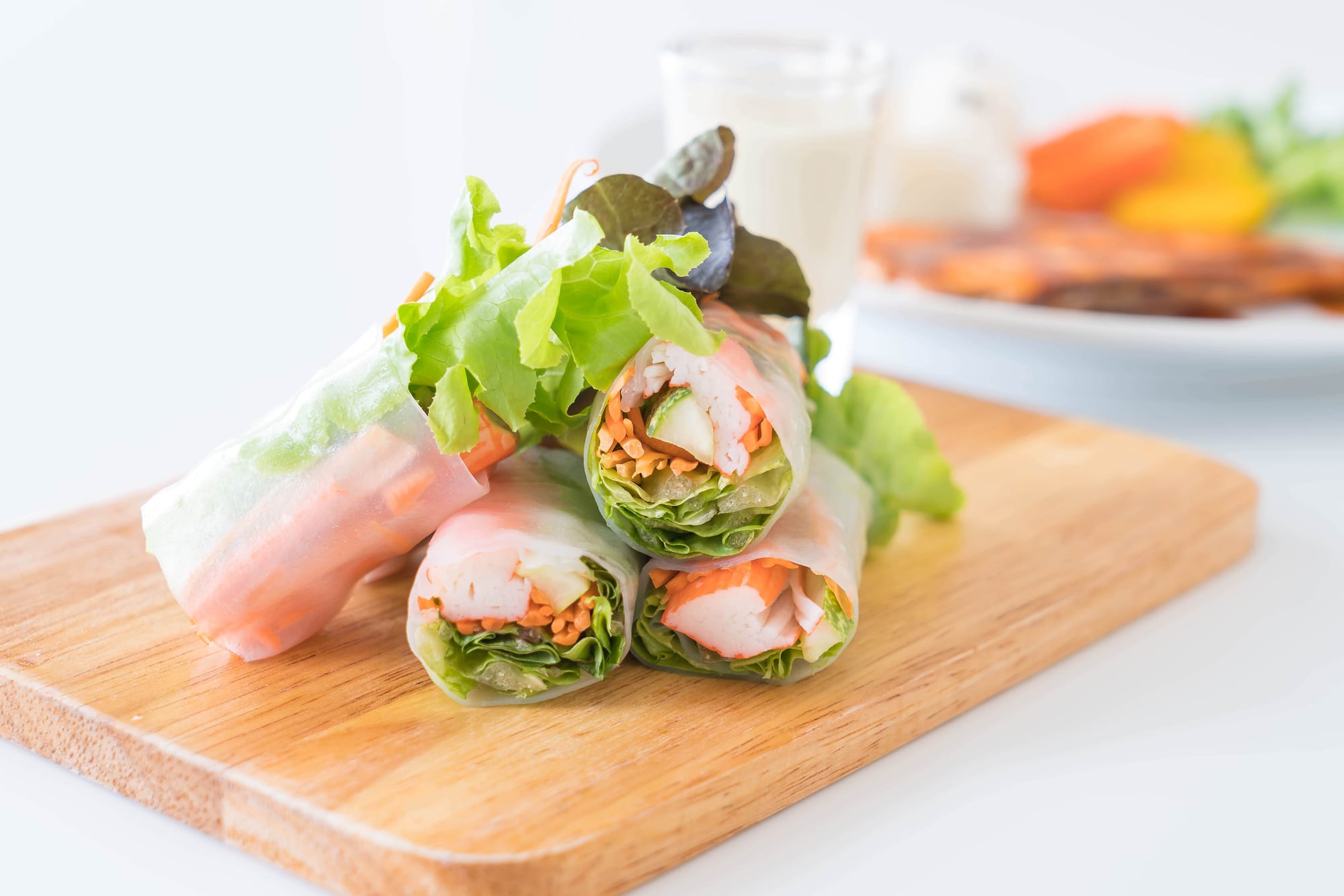 Lettuce wraps filled with shrimp and avocado on a wooden board.